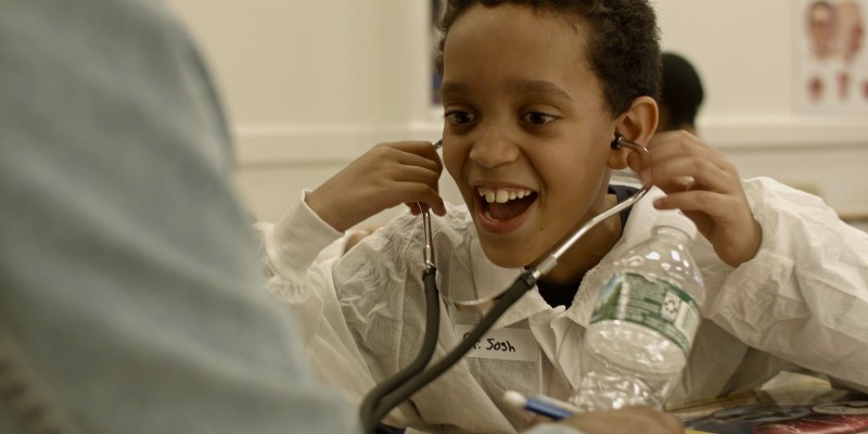 A child listens to a stethoscope.