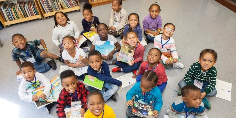 Picture of children smiling and holding books