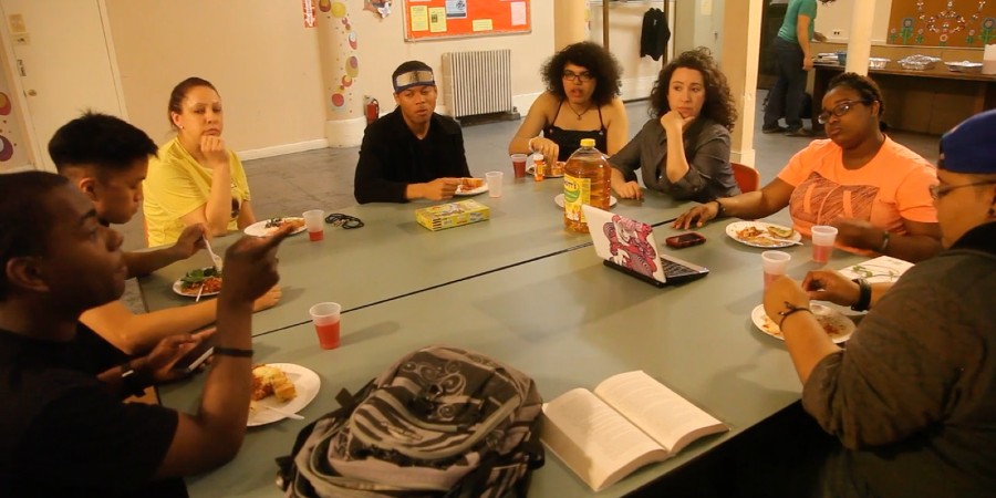A group of young people sitting around a table and eating.