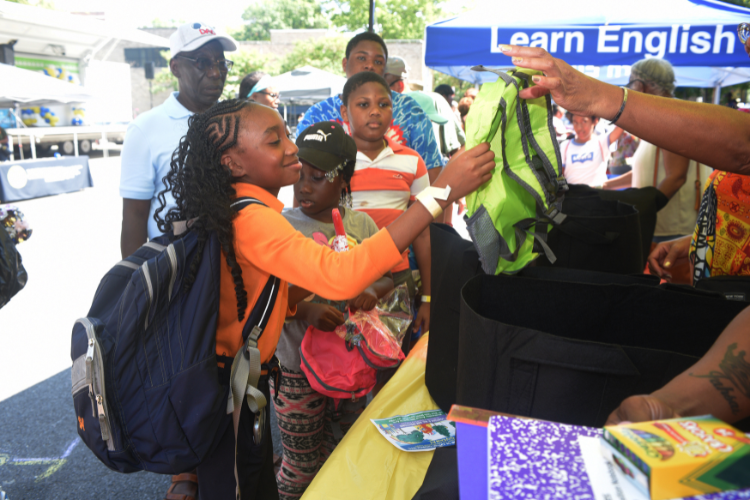 A student receives a backpack from the back to school drive event.