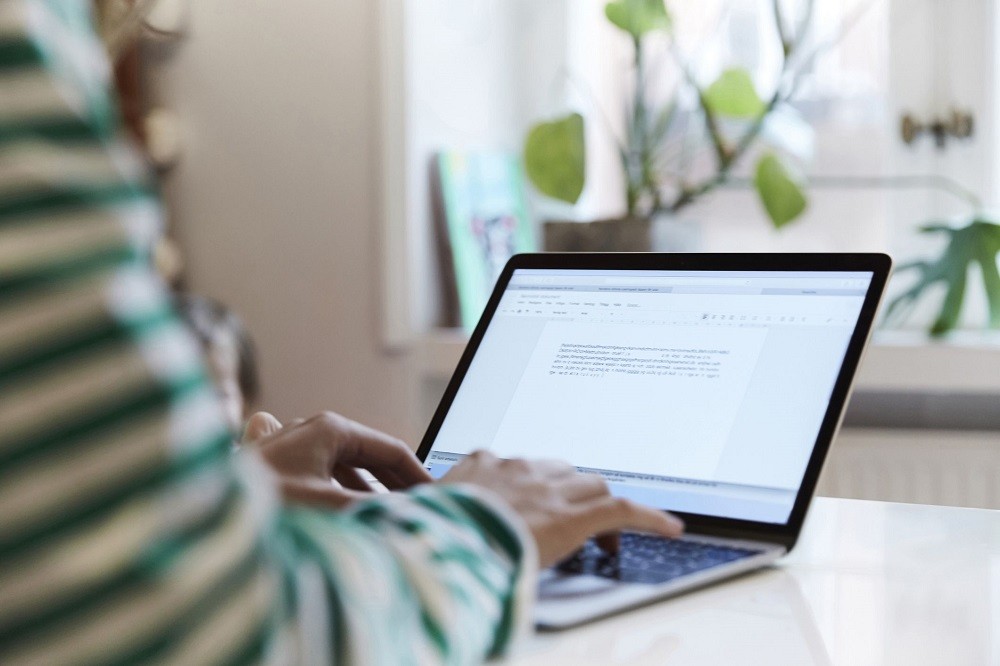 Woman's finger typing on laptop