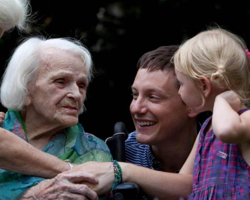 Elderly woman with middle age man and little girl - smiling.