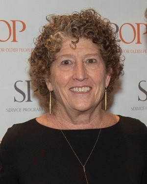 A headshot of a woman with curly hair.