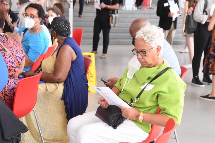 A woman in a green shirt reading a program