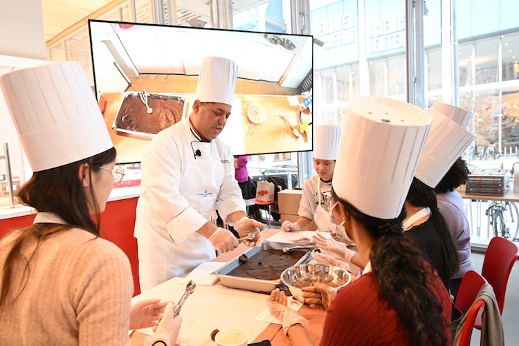 Chef Mike shows participants how to form truffles from a sheet tray of chocolate.