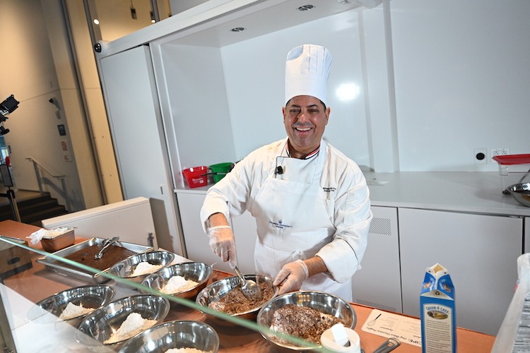 Chef Mike smiles at the camera while he cooks.