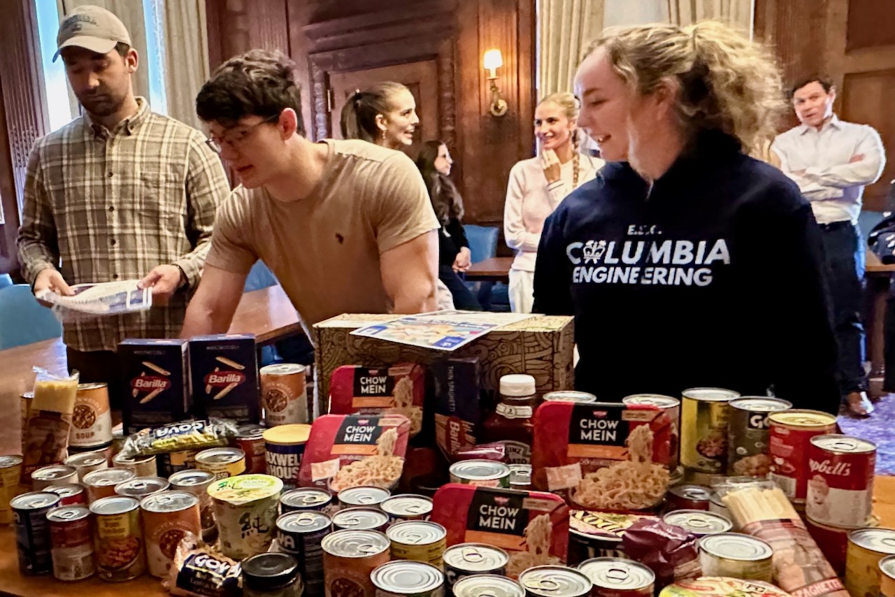 Columbia University Military veteran students stand at a table full of packaged foods.