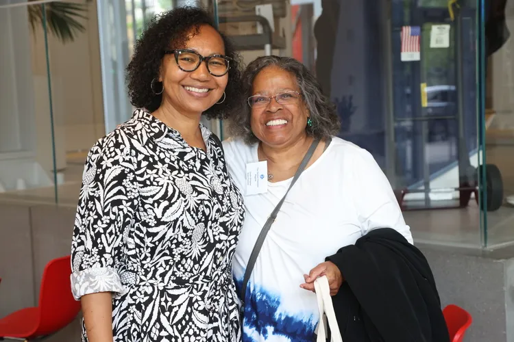 two women smile and pose for a photo