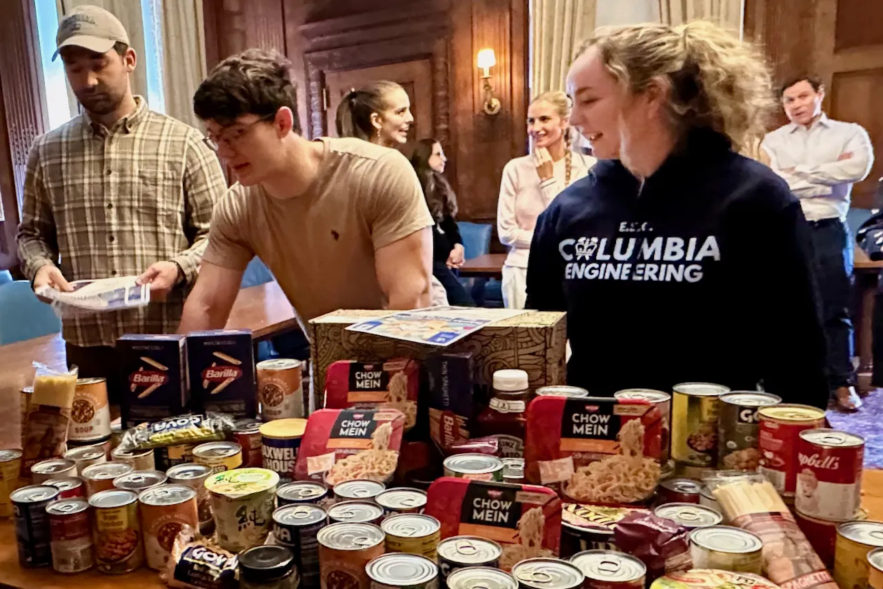 Columbia University Military veteran students stand at a table full of packaged foods.