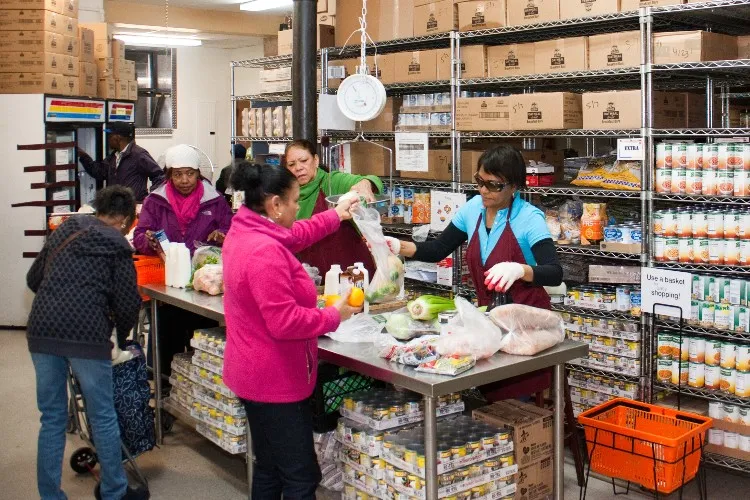 People at food pantry gathering food. 